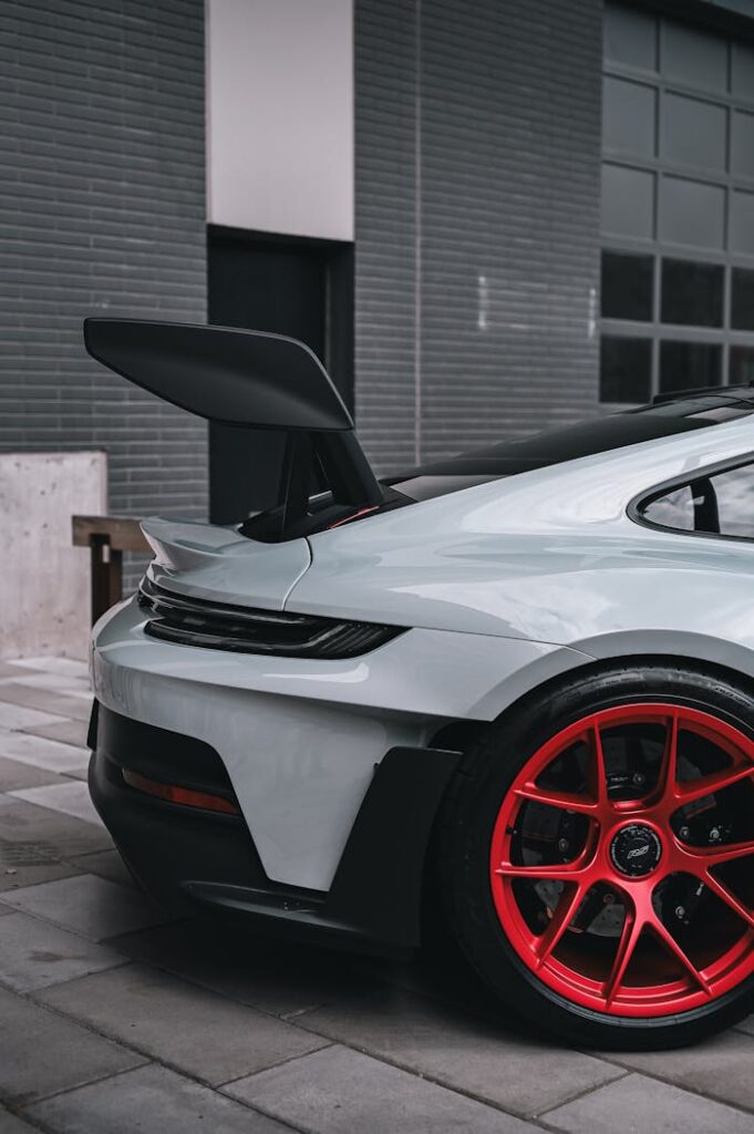 Detailed view of a modern sports car with eye-catching red wheels and custom features.